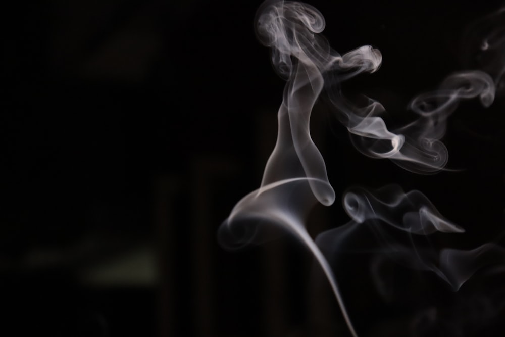 smoke is shown in the dark on a black background