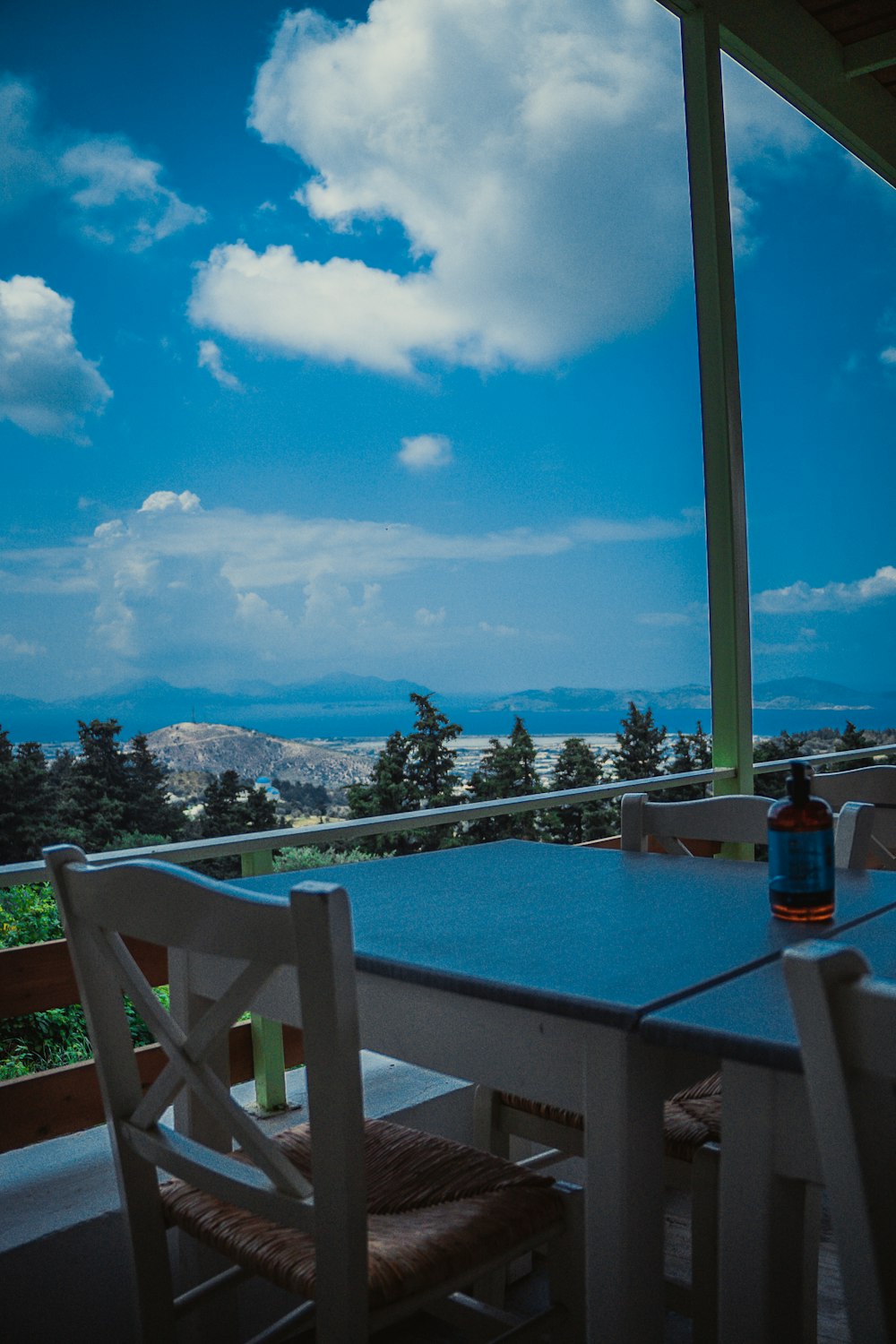 a table and chairs with a view of the ocean