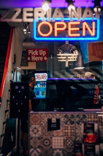 a restaurant with a neon sign that says open