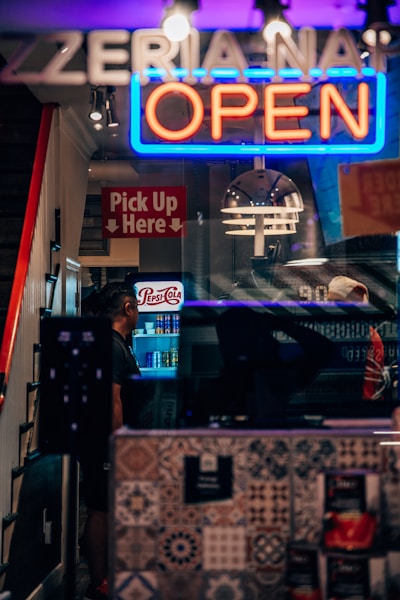 a restaurant with a neon sign that says open