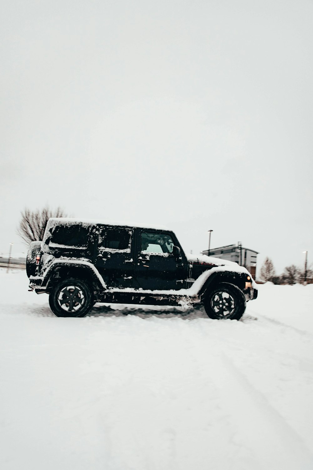 a black jeep is parked in the snow