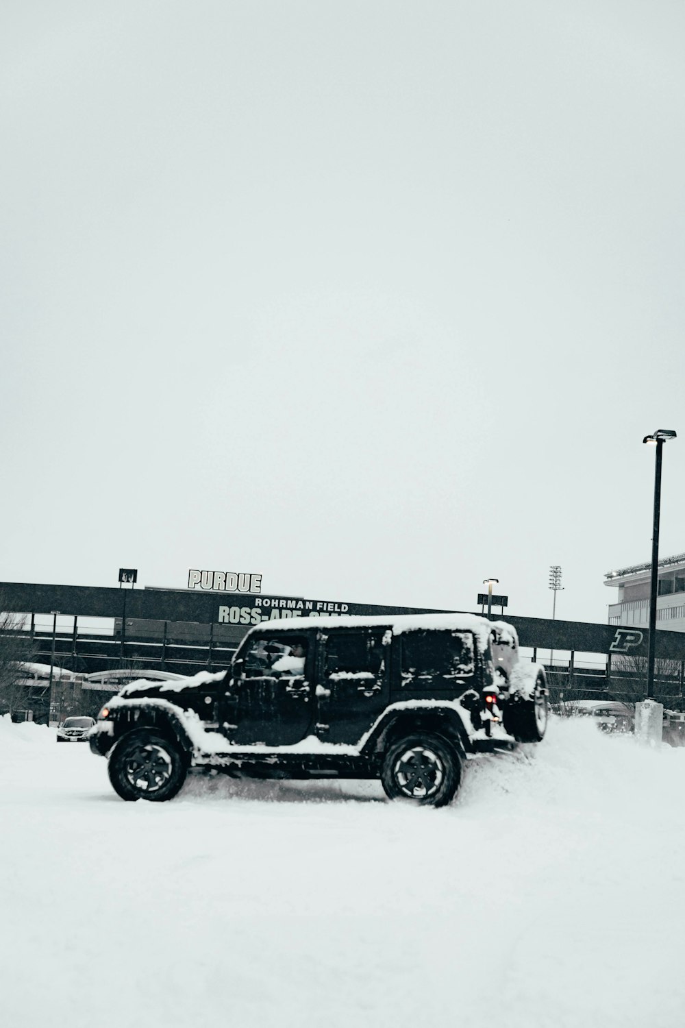 a jeep parked in the snow in front of a building