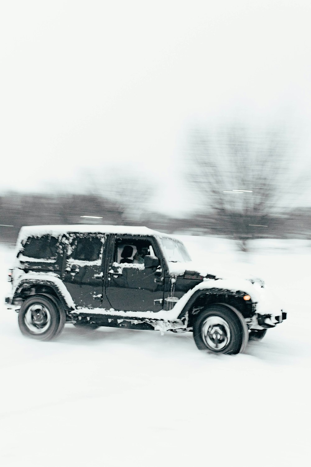 a black and white photo of a jeep in the snow