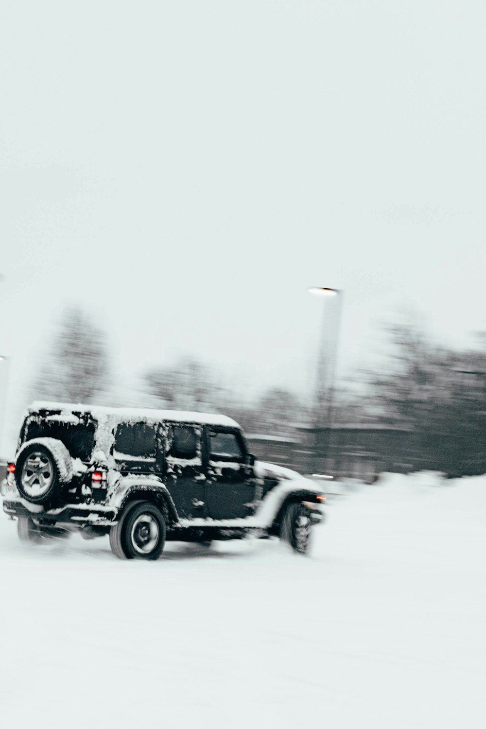 a jeep driving down a snow covered road