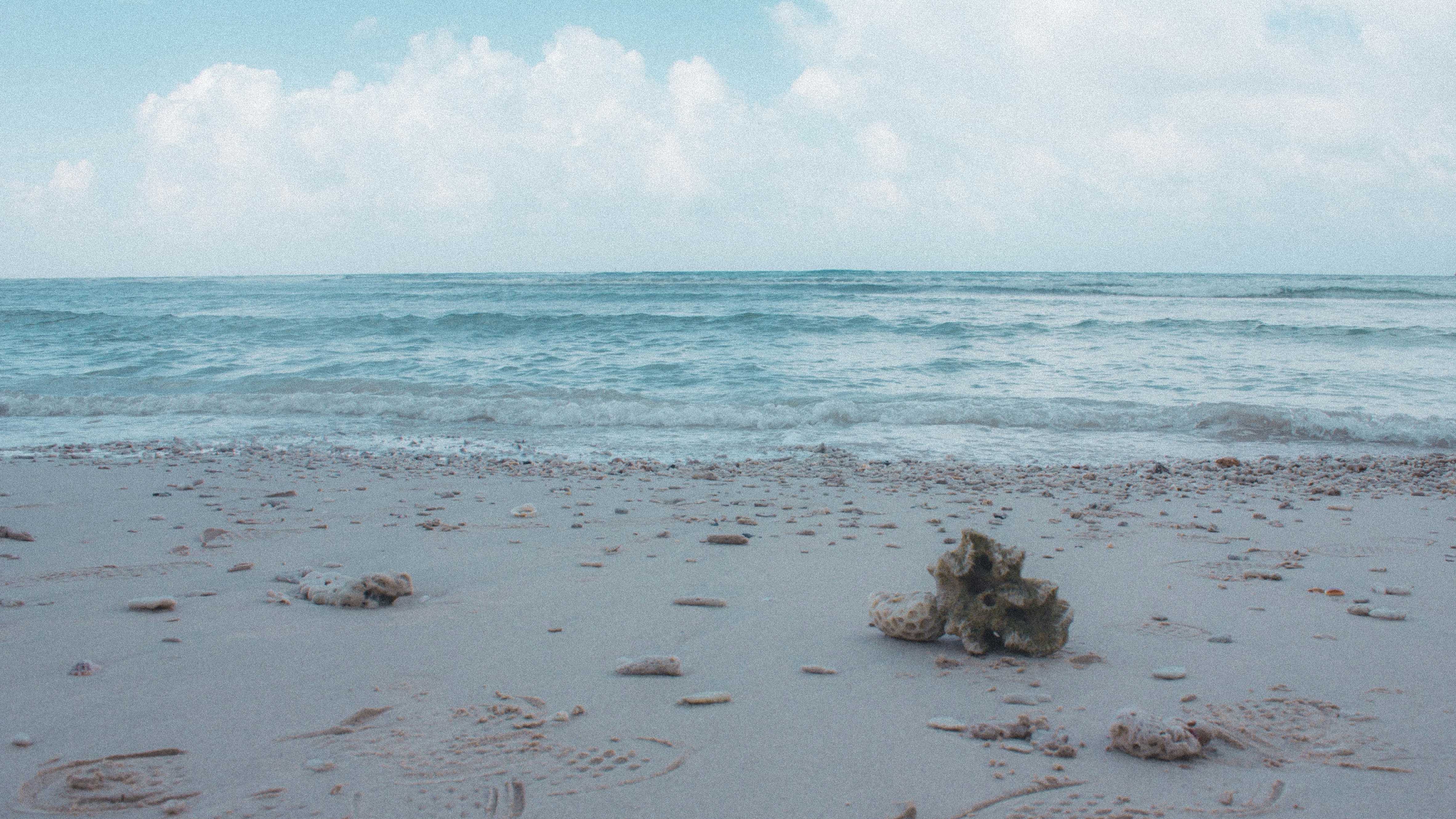 a sandy beach with waves coming in to shore