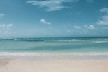 A serene beach view with soft waves lapping at the shore.