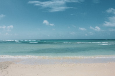 A serene beach view with soft waves lapping at the shore.
