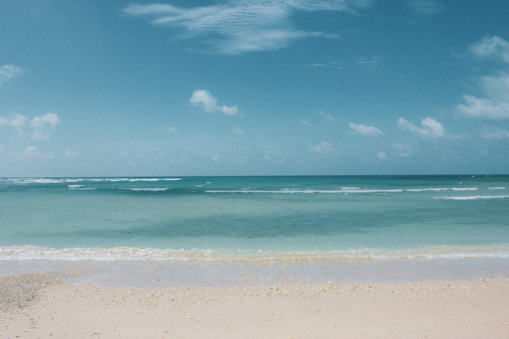 a sandy beach with waves coming in to shore