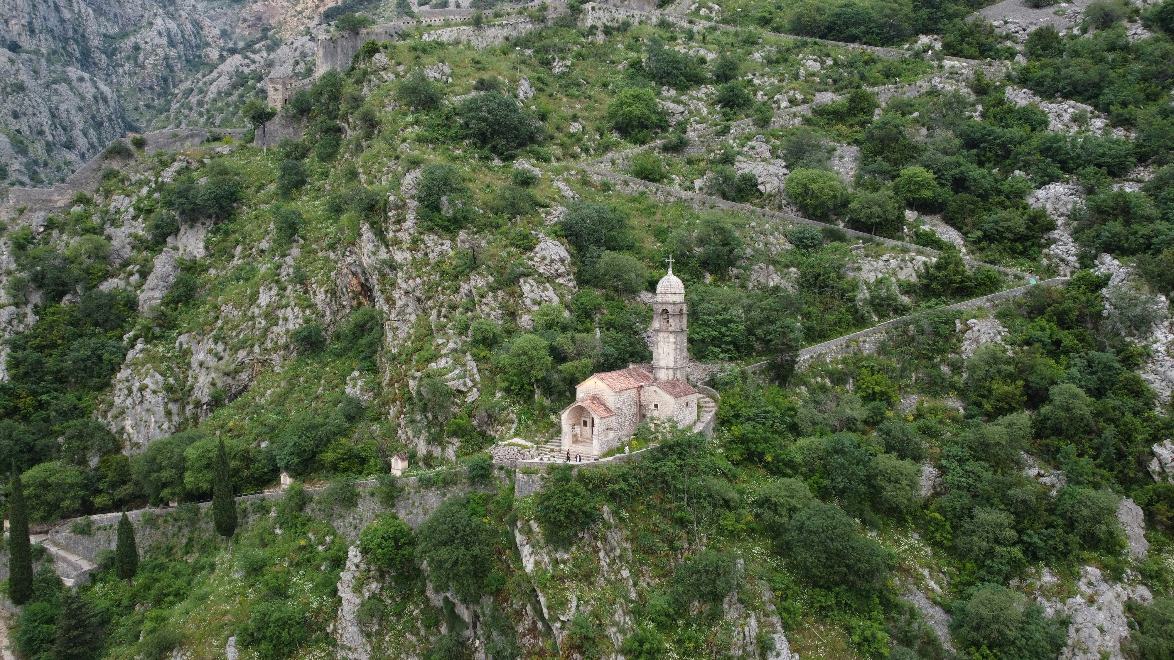 a church on a steep hill surrounded by trees