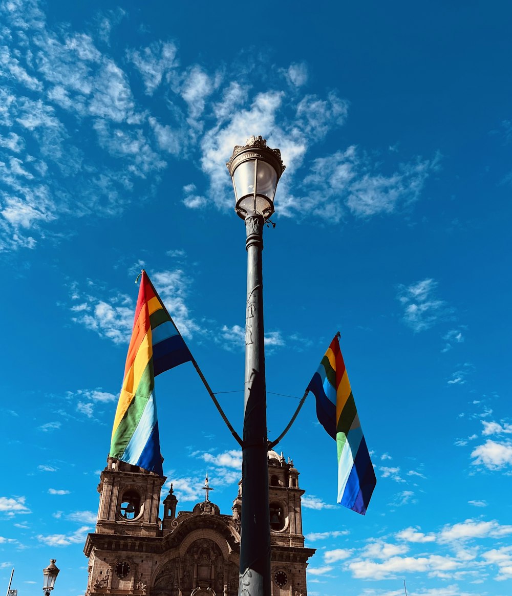 a street light with three rainbow flags on it