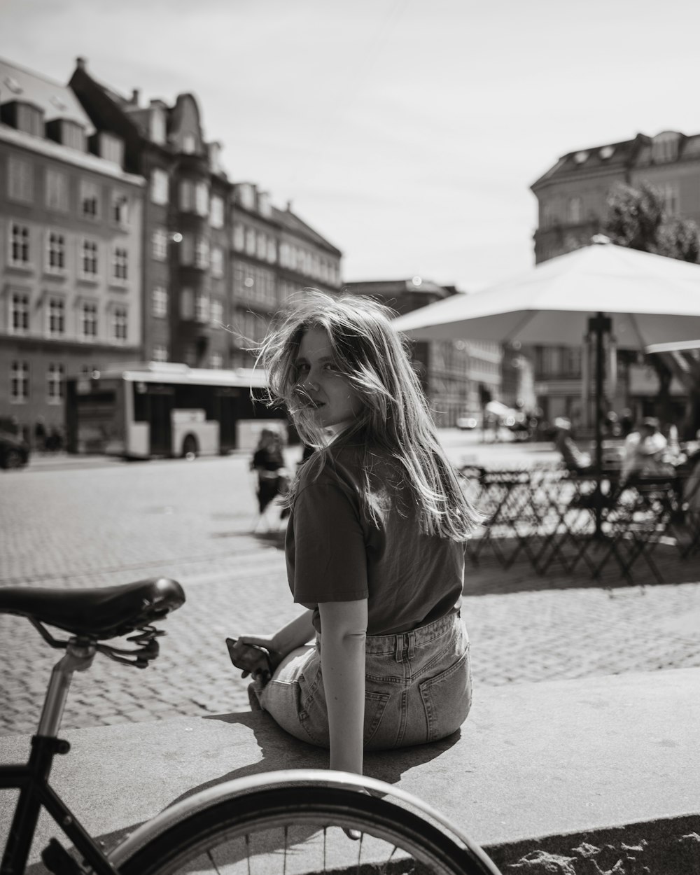una donna seduta a terra accanto a una bicicletta