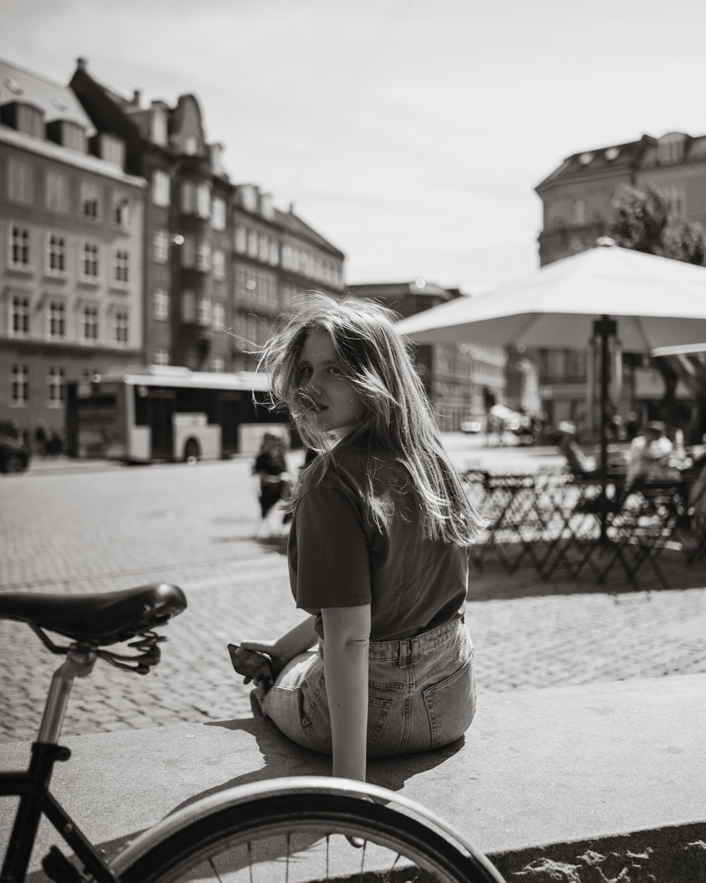 a woman sitting on the ground next to a bike