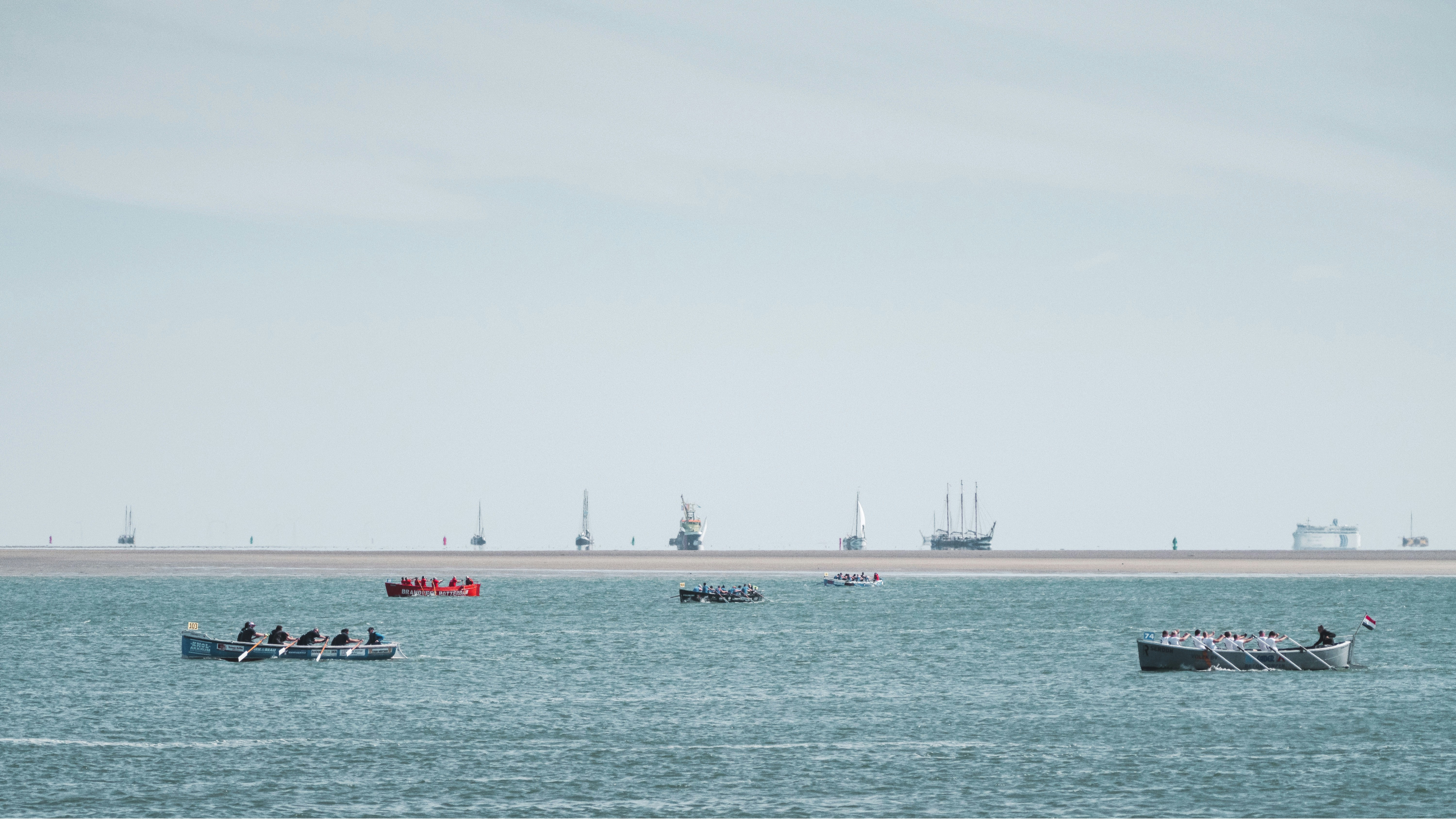 eine Gruppe von Booten, die auf einem großen Gewässer schwimmen