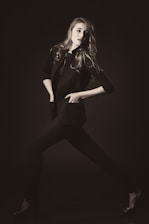A stylish woman wearing a tailored blazer and elegant dress in a bright, airy setting.