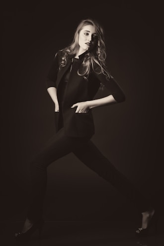 A stylish young woman confidently posing in a chic outfit.