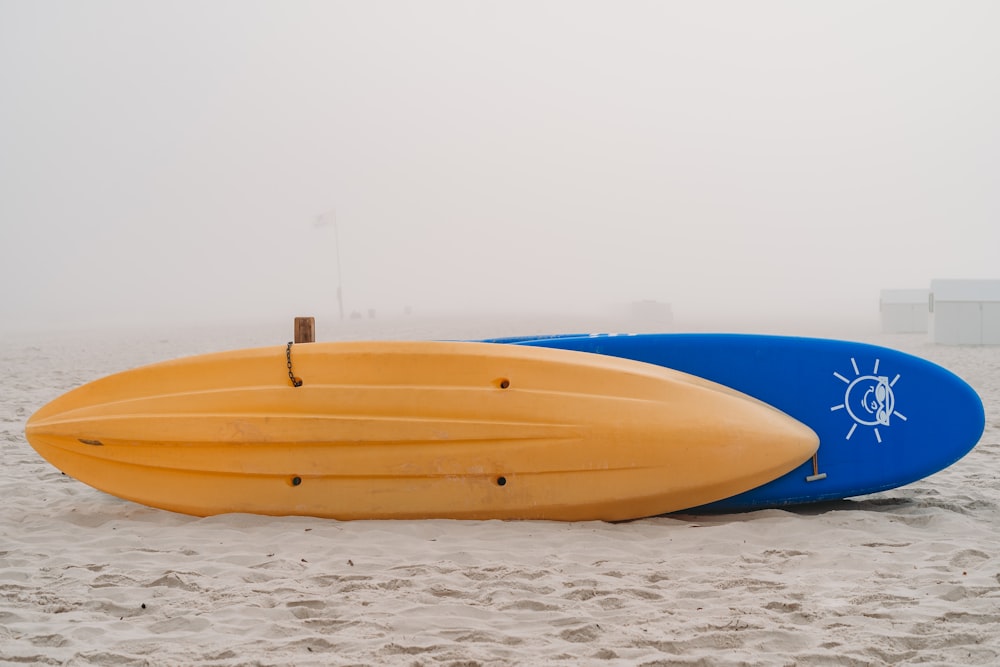 Un paio di tavole da surf seduti in cima a una spiaggia sabbiosa