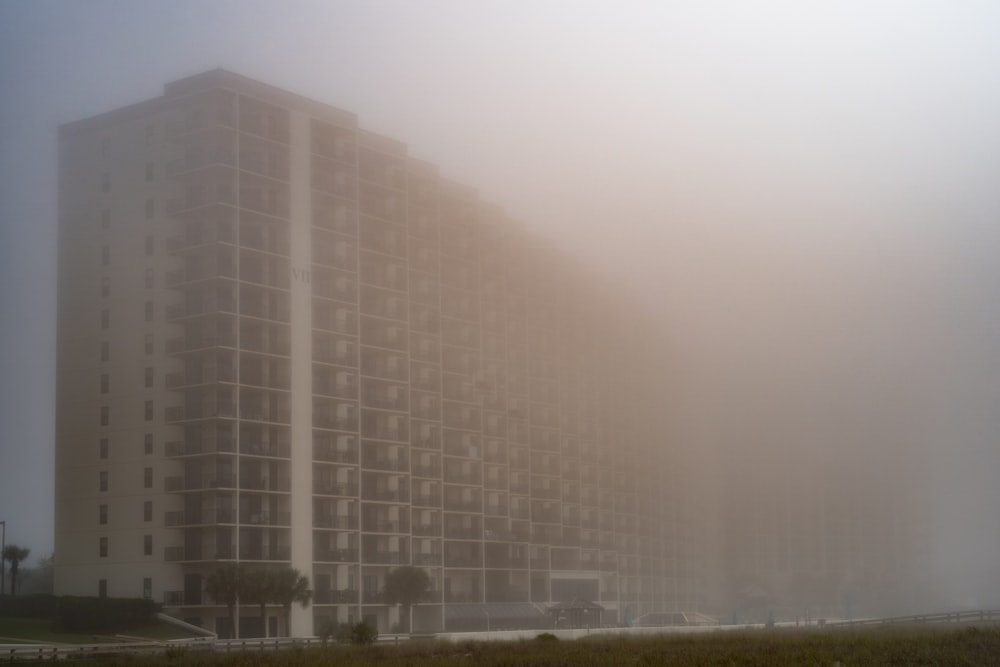 a tall building in the middle of a foggy day