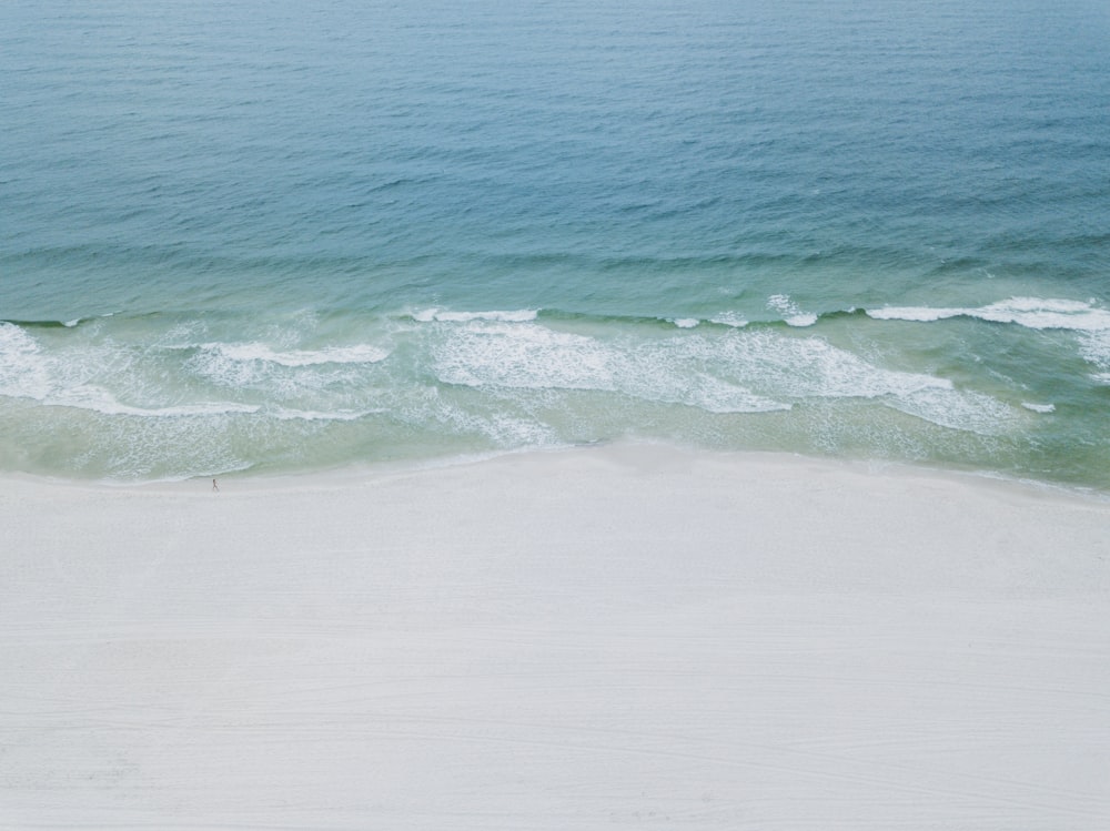 a person riding a surfboard on top of a sandy beach