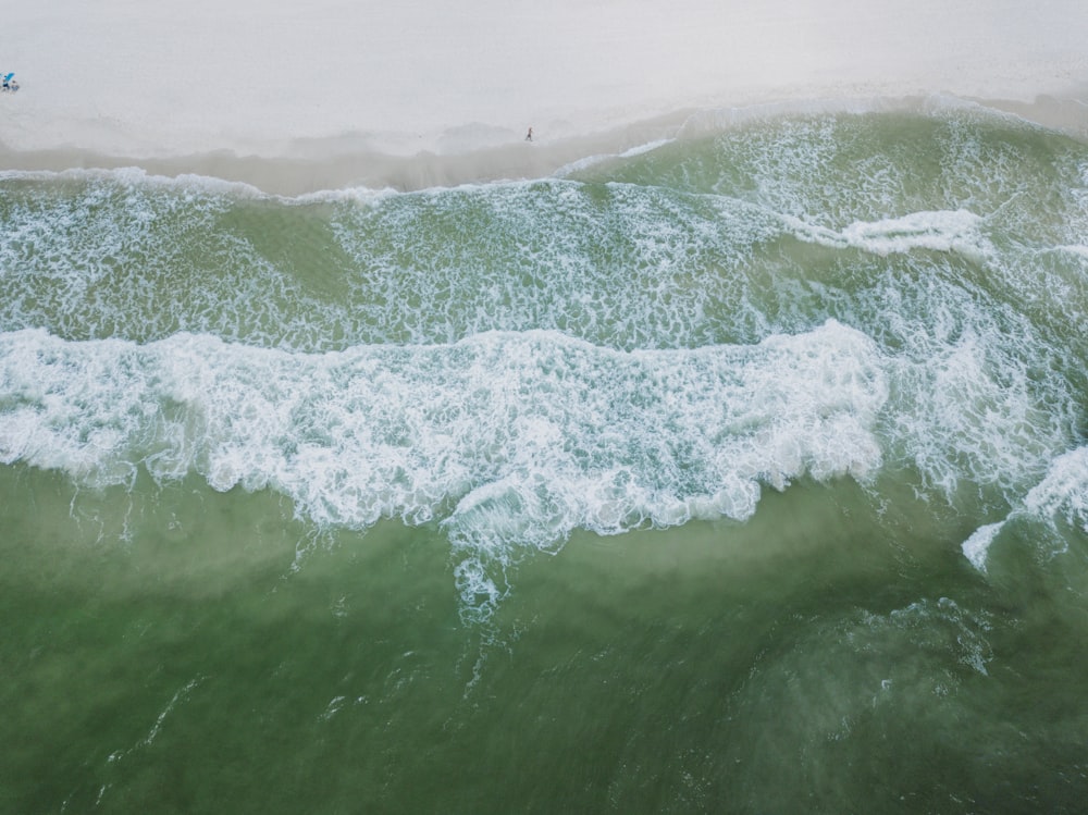 una persona montando una tabla de surf en una ola en el océano