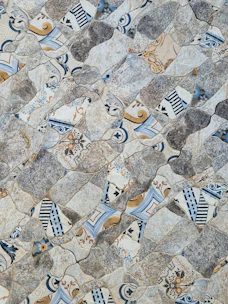 Close-up of a vibrant mosaic tile pattern inspired by Mani's rugged landscape.