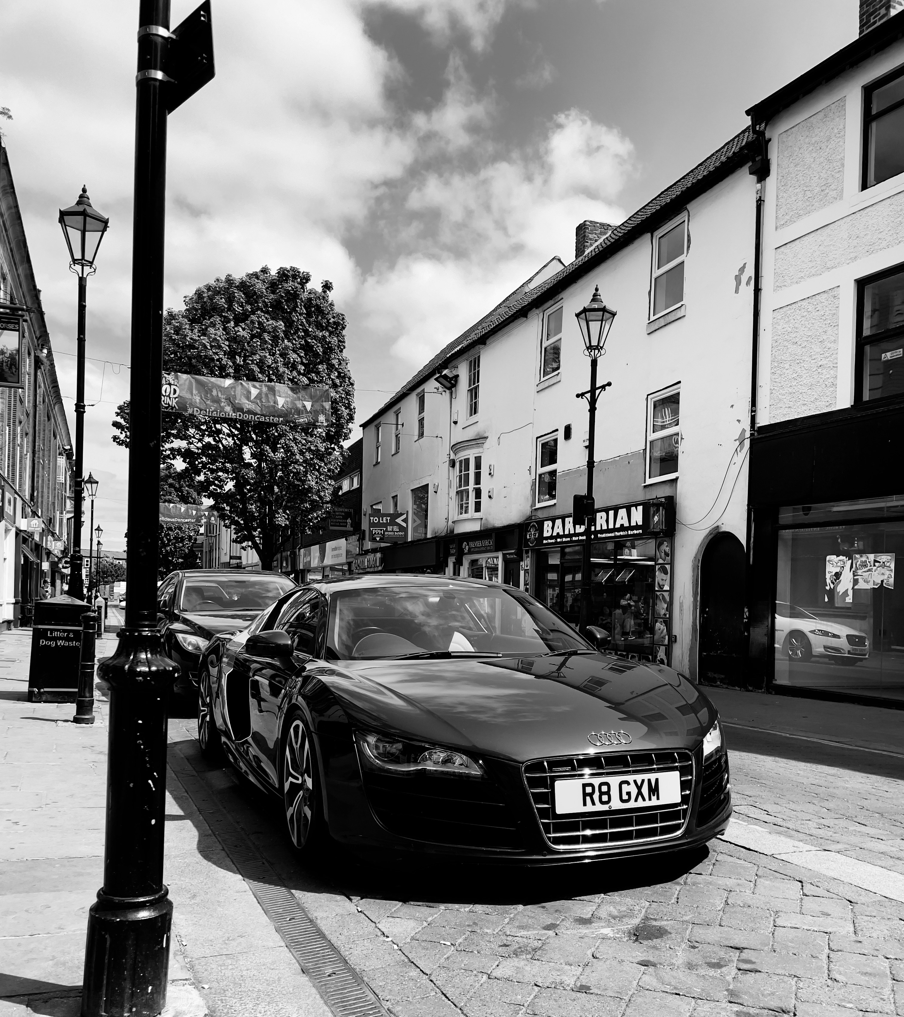 a black and white photo of a car parked on the side of the road