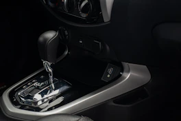a close up of a car's gear box and steering wheel