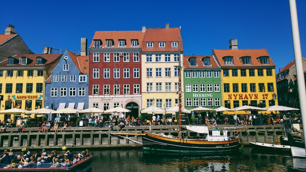 a group of people sitting on a boat in front of some buildings