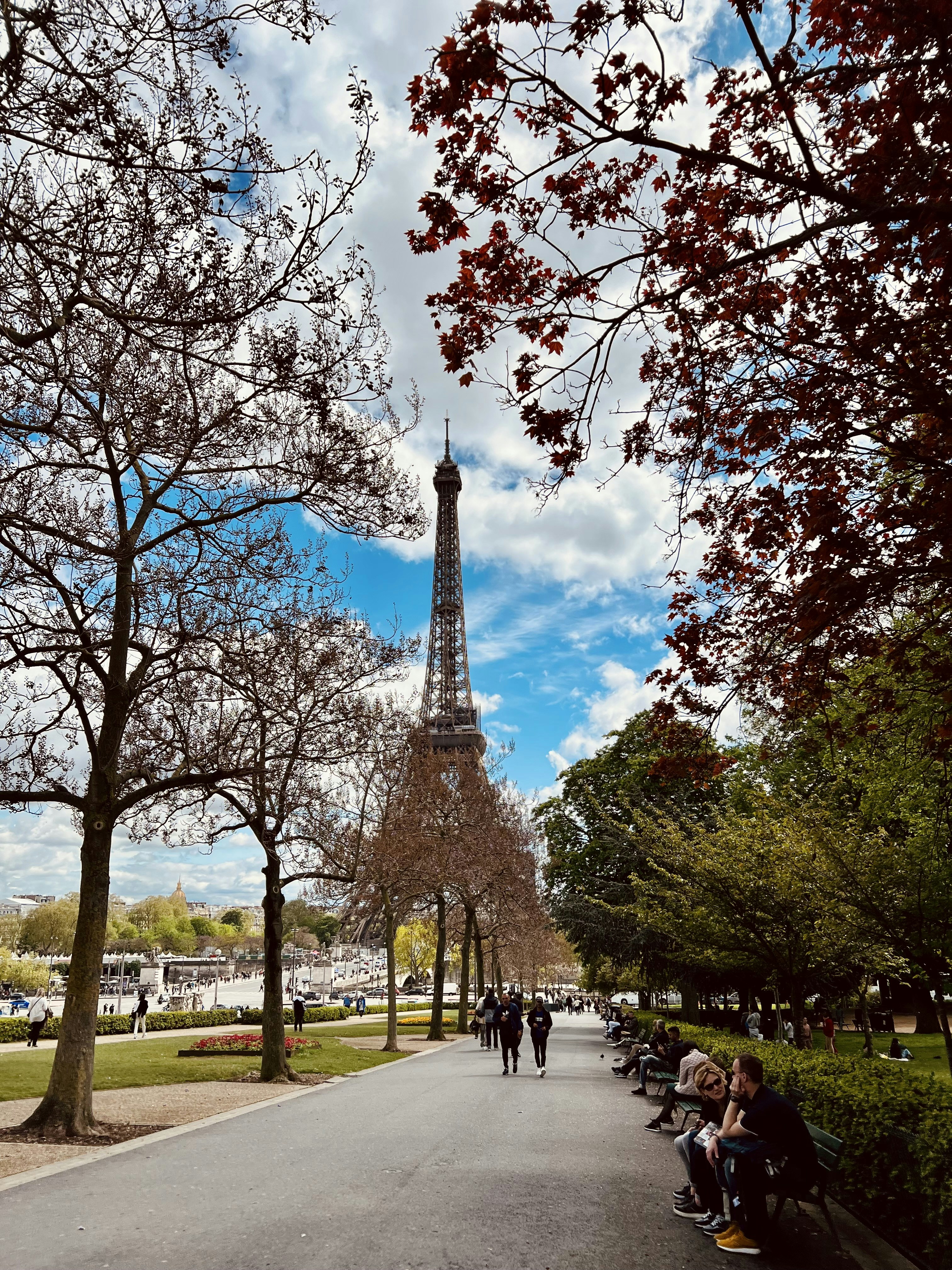 a group of people sitting on a bench in front of the eiffel tower