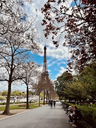 a group of people sitting on a bench in front of the eiffel tower