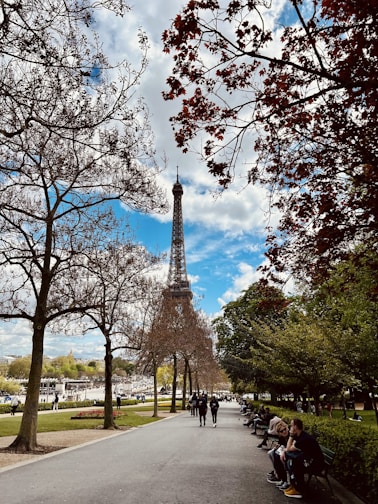 a group of people sitting on a bench in front of the eiffel tower