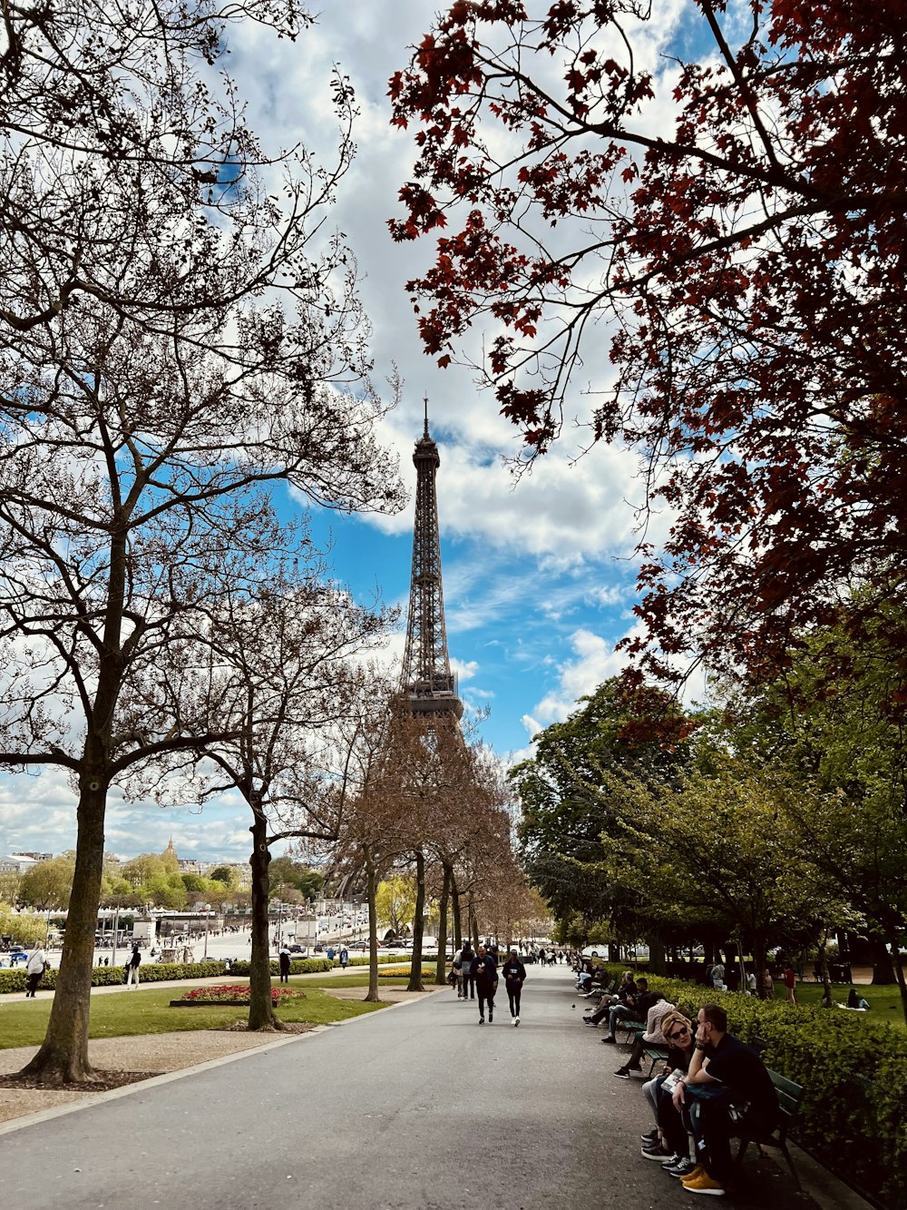 a group of people sitting on a bench in front of the eiffel tower