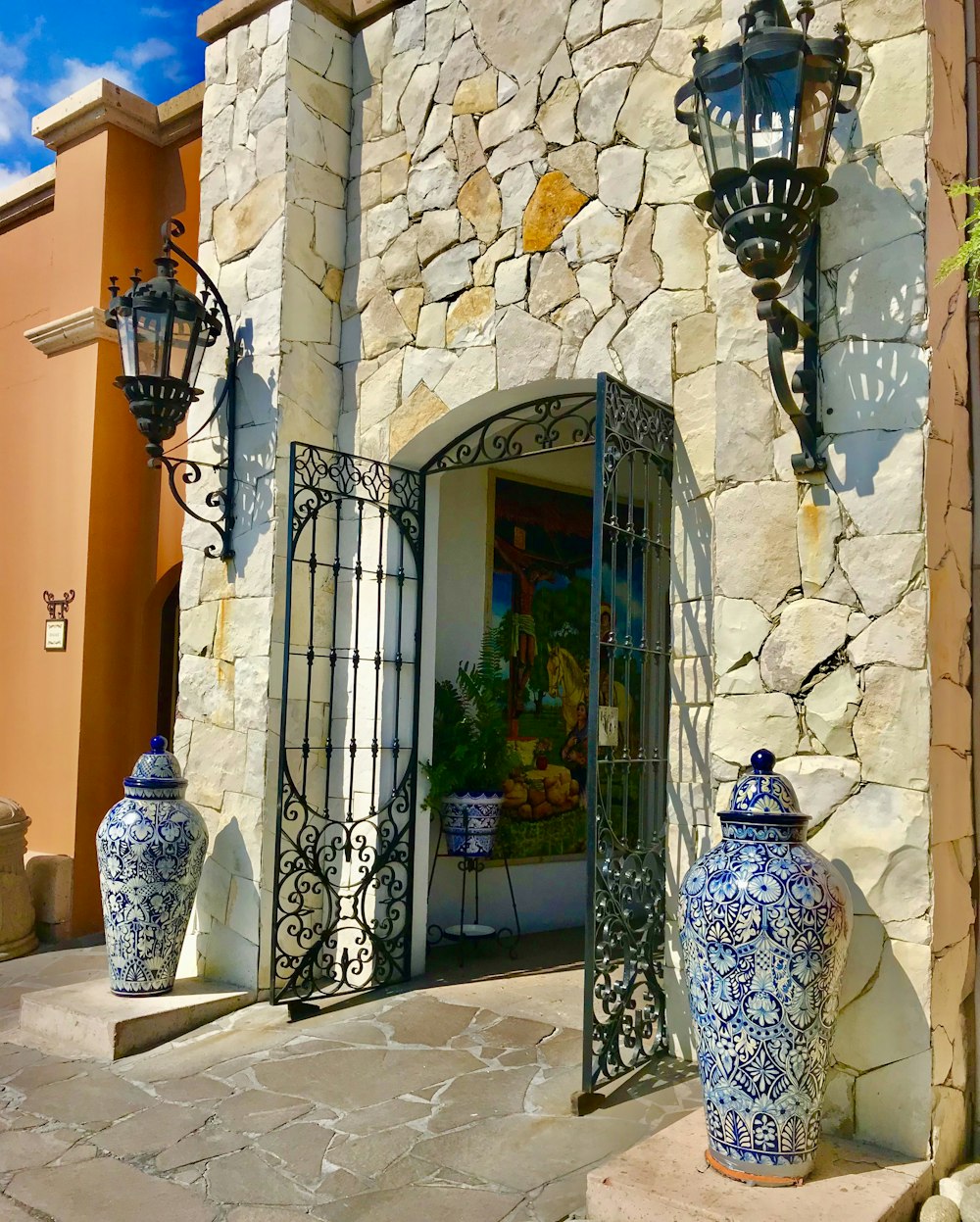 a stone building with a large blue and white vase in front of it