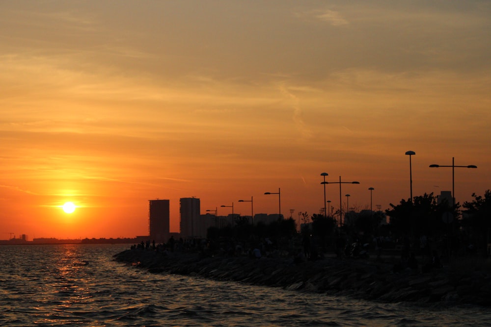 a sunset over a body of water with a city in the background