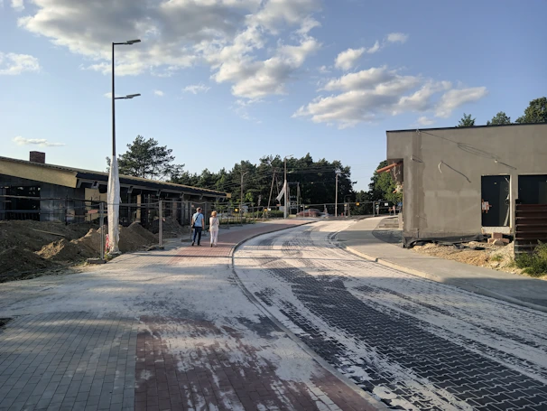 Local community members smiling beside the new road, symbolizing progress and better quality of life.