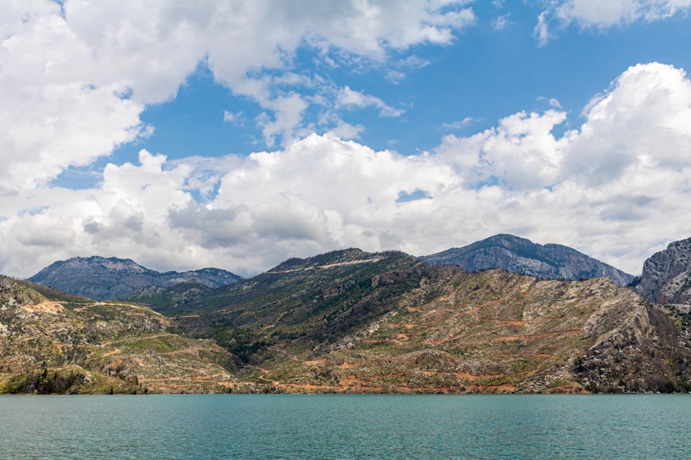 a body of water with mountains in the background