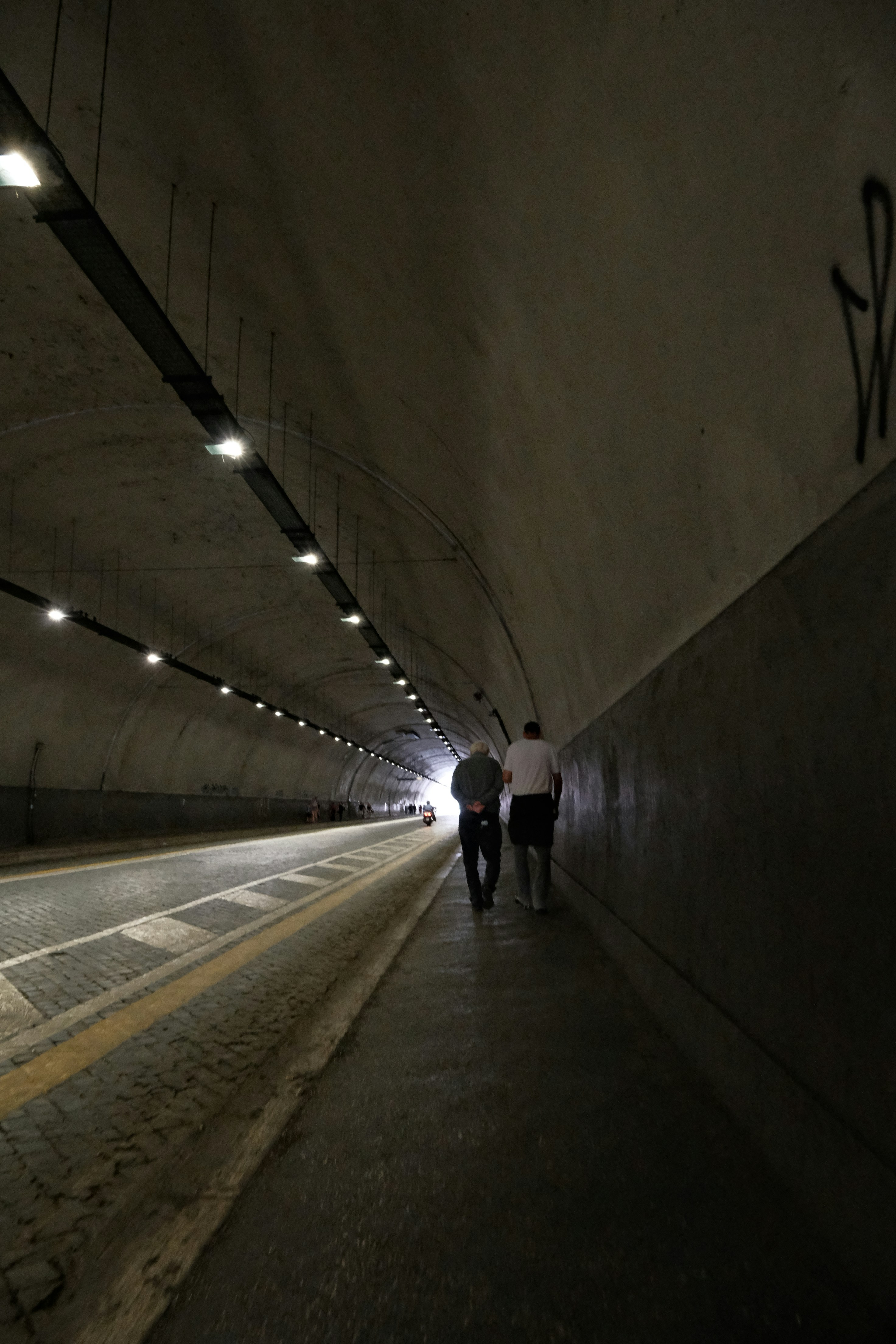 Un couple de personnes qui marchent dans un tunnel