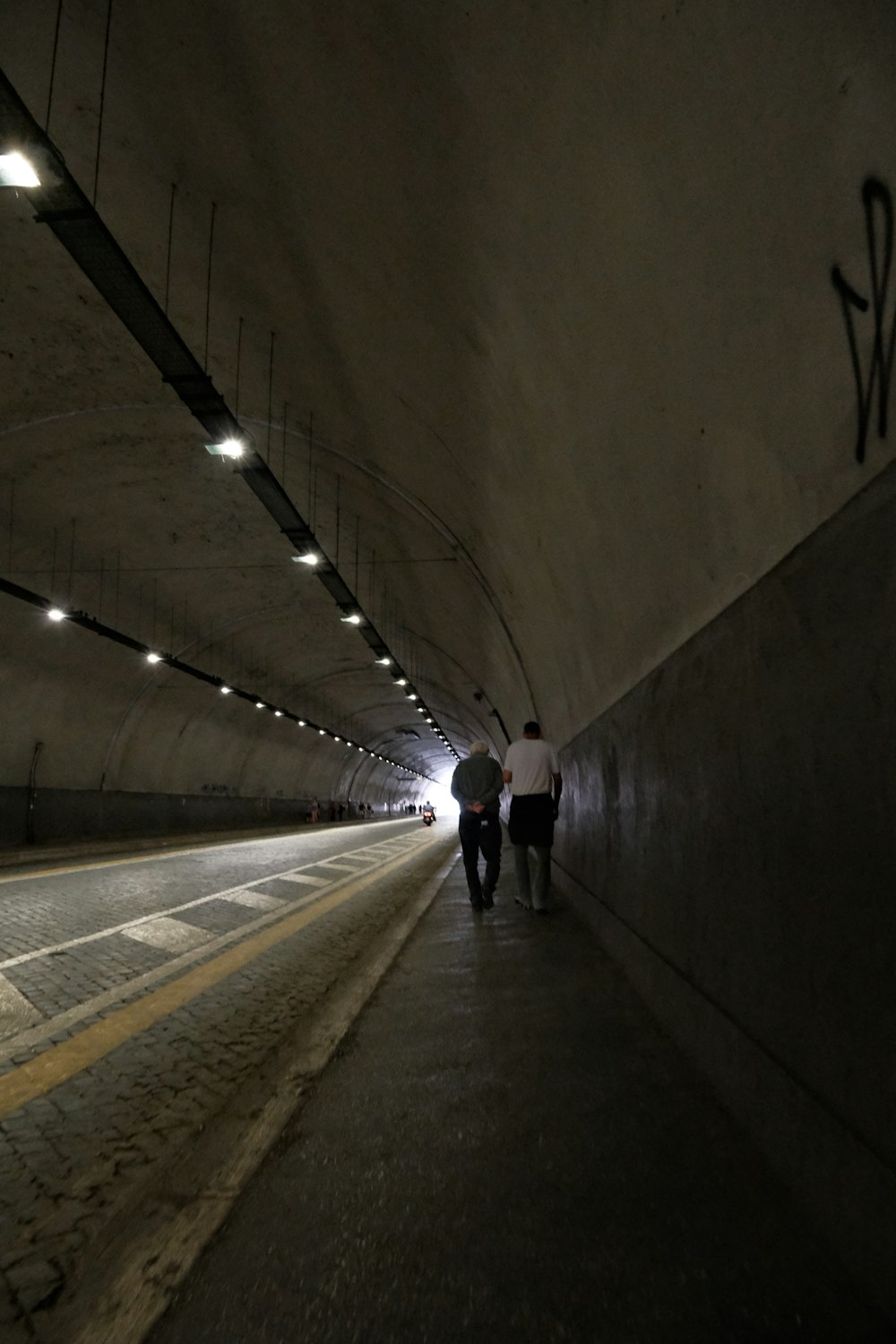 a couple of people that are walking in a tunnel