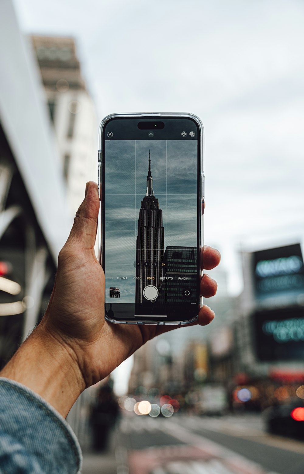 a person taking a picture of the empire building