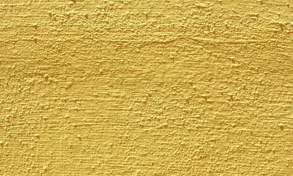 a close up of a yellow painted wall