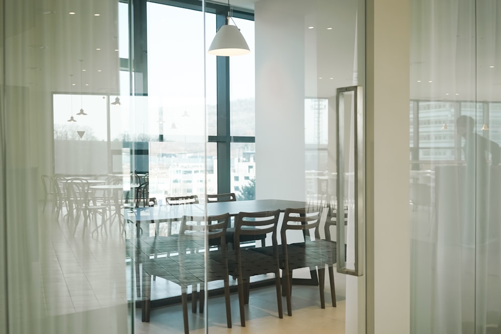 a dining room table and chairs in front of a large window