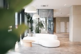 a white couch sitting in a living room next to a plant