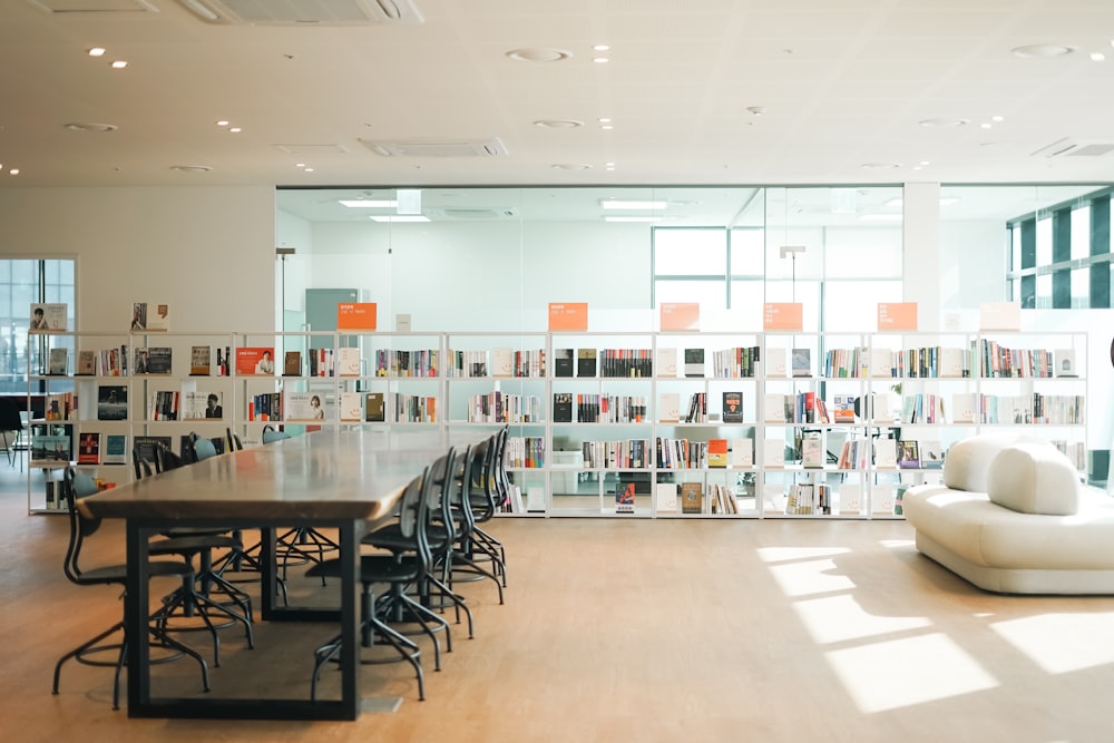 a long table in a large room with a lot of books on the wall