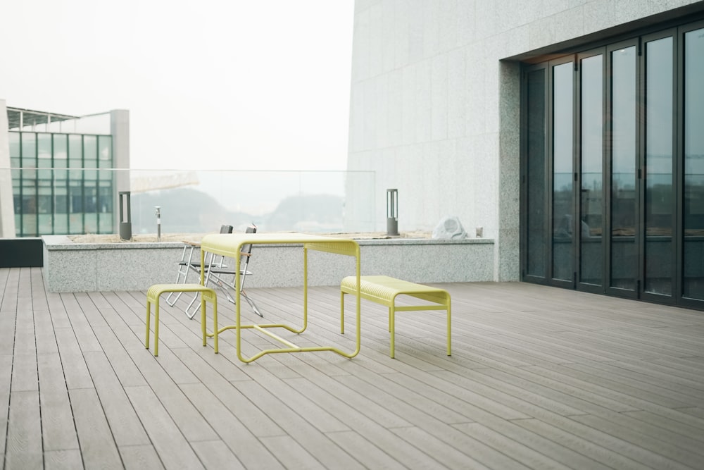 a yellow table and two chairs on a wooden floor