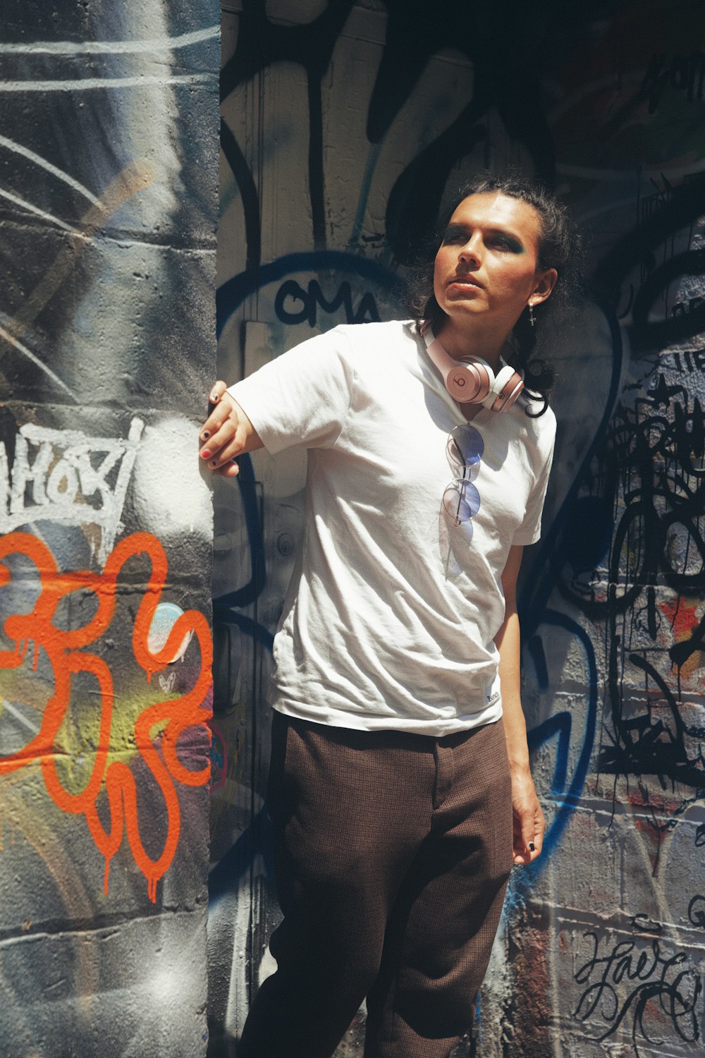 a man standing next to a wall covered in graffiti