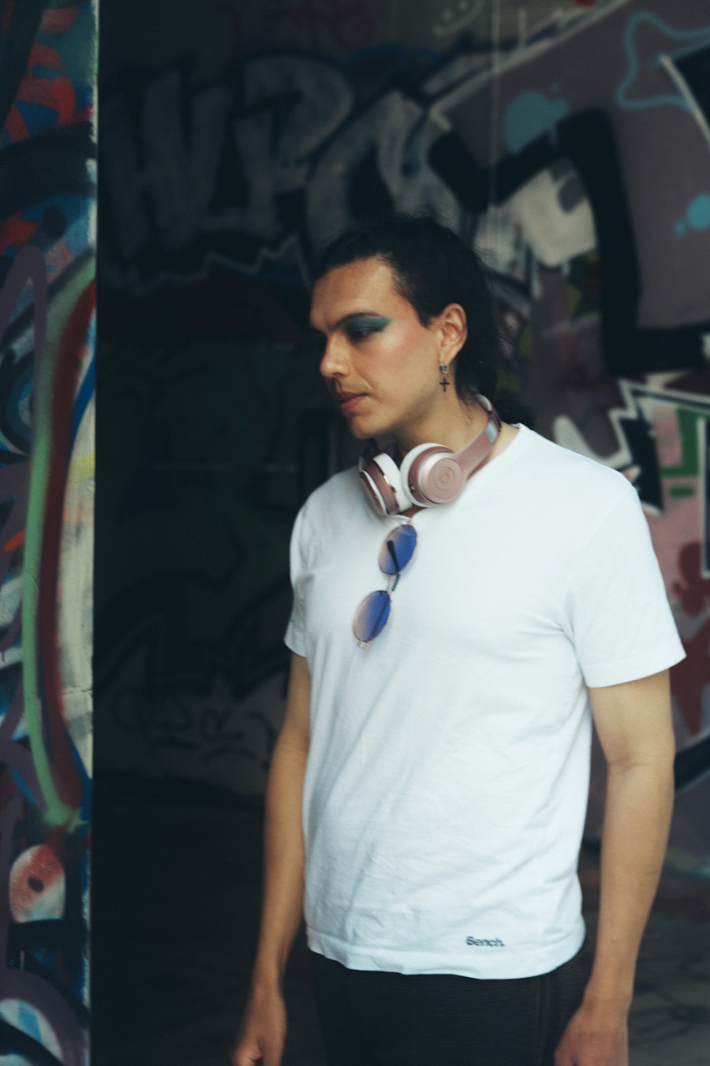 a man standing in front of a graffiti covered wall