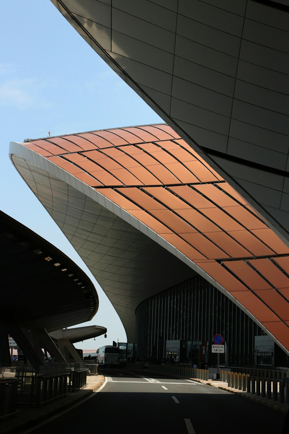 a large building with a curved roof next to a street