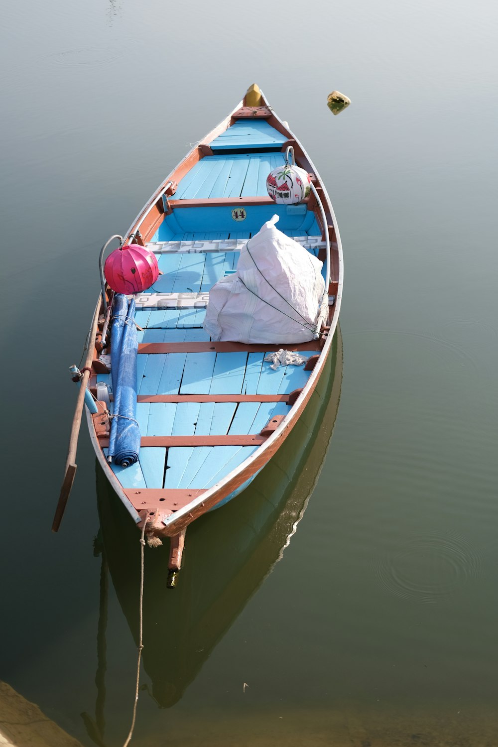 a small blue boat floating on top of a body of water