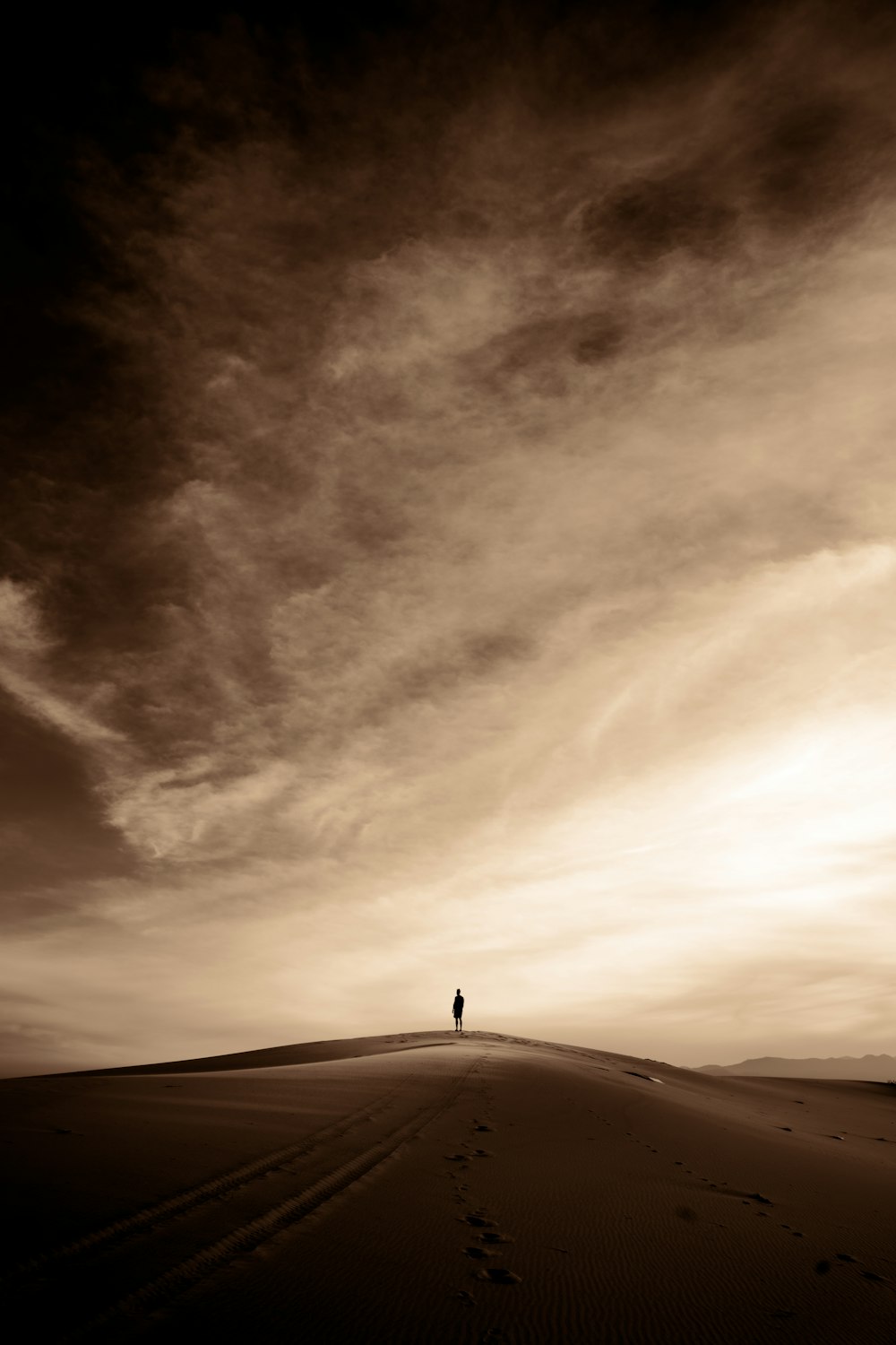 a person standing on top of a sandy hill