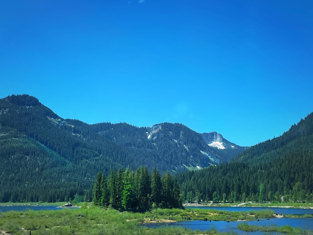 a scenic view of a mountain range with a river in the foreground