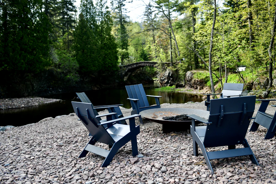 Chairs around a fire pit on a gravel terrace by the woods